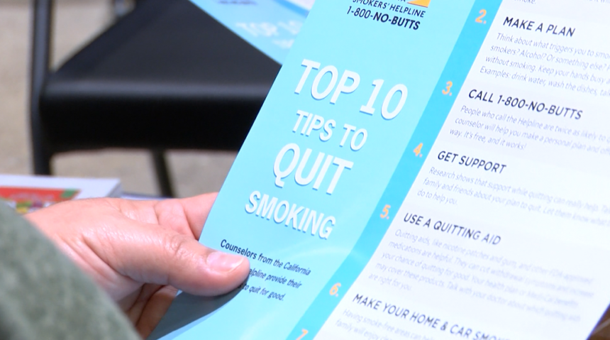 Event goer holds info on how to quit smoking