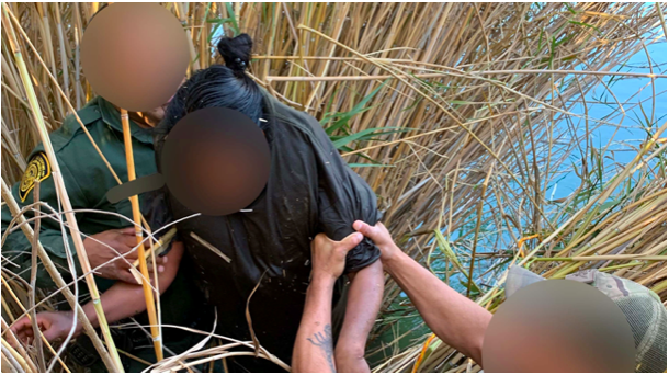 Border Patrol agents pull a woman out of the waters of the All American Canal