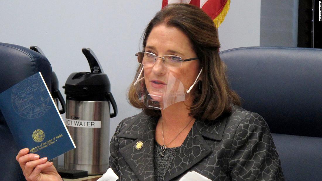 FILE - In this Jan. 27, 2021 file photo, Alaska state Sen. Lora Reinbold, an Eagle River Republican, holds a copy of the Alaska Constitution during a committee hearing in Juneau, Alaska. Alaska Airlines has banned the Alaska state senator for refusing to follow mask requirements. Last week Reinbold was recorded in Juneau International Airport arguing with Alaska Airlines staff about mask policies. A video posted to social media appears to show airline staff telling Reinbold her mask must cover her nose and mouth. Reinbold has been a vocal opponent to COVID-19 mitigation measures and has repeatedly objected to Alaska Airlines' mask policy, which was enacted before the federal government's mandate this year. (AP Photo/Becky Bohrer, File)