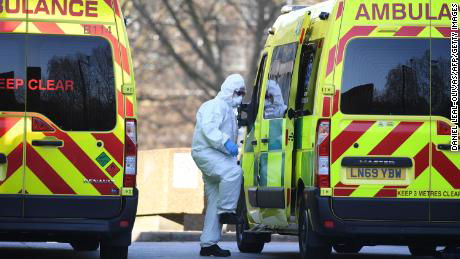 A member of the ambulance service wearing personal protective equipment is seen leading a patient (unseen) into an ambulance at St Thomas' Hospital in London on March 24, 2020. - Britain's leaders on Tuesday urged people to respect an unprecedented countrywide lockdown, saying that following advice to stay at home would stop people dying of coronavirus. (Photo by DANIEL LEAL-OLIVAS / AFP) (Photo by DANIEL LEAL-OLIVAS/AFP via Getty Images)