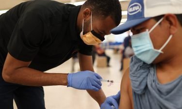 Odilest Guerrier administers a Moderna COVID-19 vaccine to Pasqual Cruz at a clinic set up by Healthcare Network in Immokalee