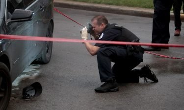 Police investigate the scene of a shooting in the Auburn Gresham neighborhood on July 21