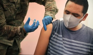 Maryland National Guard Specialist James Truong (L) administers a Moderna coronavirus vaccine at CASA de Maryland's Wheaton Welcome Center on May 21 in Wheaton
