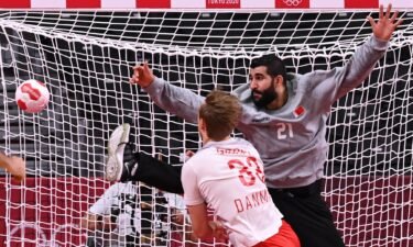 Bahrain's goalkeeper Mohamed A.Husain (R) fails to stop a shot during the men's preliminary round Group B handball match between Denmark and Bahrain of the Tokyo 2020 Olympic Games.