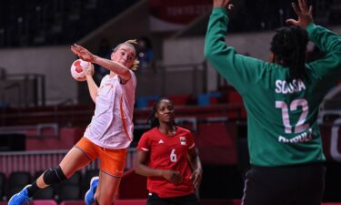 Netherlands' left wing Bo van Wetering (L) jumps to shoot during the women's preliminary round group A handball match between The Netherlands and Angola