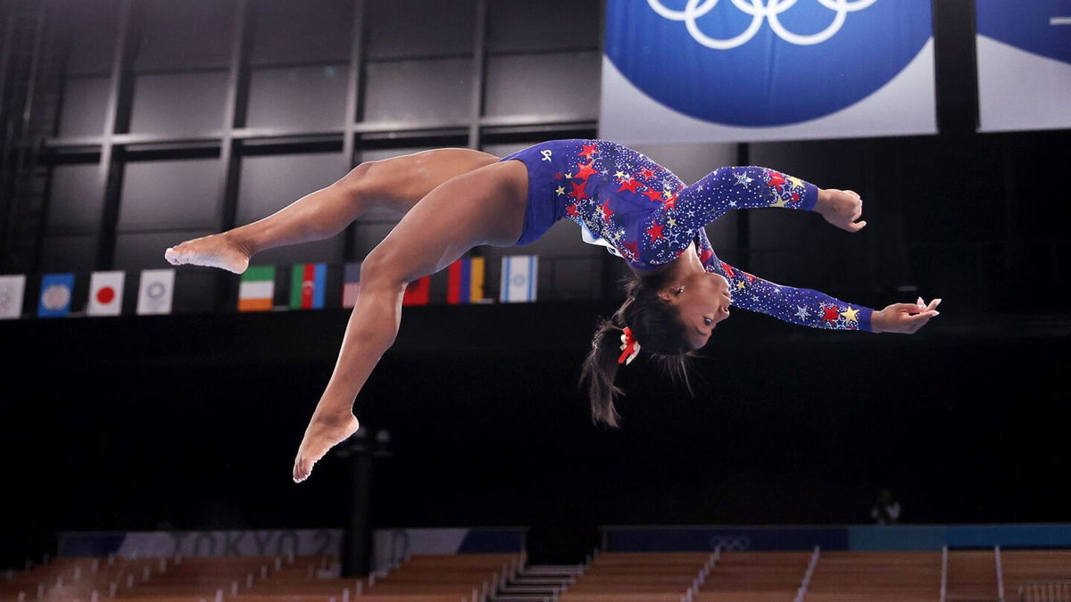 Simone Biles does a layout on the balance beam during women's gymnastics qualifications