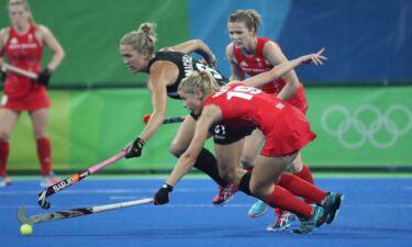 Field hockey players vie for the ball.