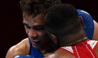 Morocco's Youness Baalla (red) and New Zealand's David Nyika fight during their men's heavy (81-91kg) preliminaries round of 16 boxing match during the Tokyo 2020 Olympic Games at the Kokugikan Arena in Tokyo on July 27