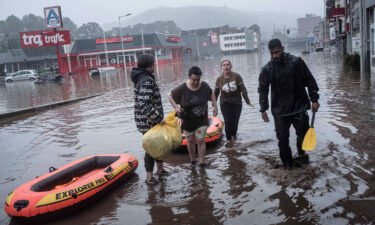 Residents use rubber rafts to evacuate after the Meuse River broke its banks during heavy flooding in Liege