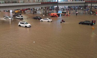 People stranded in flood waters along a street following heavy rains in Zhengzhou