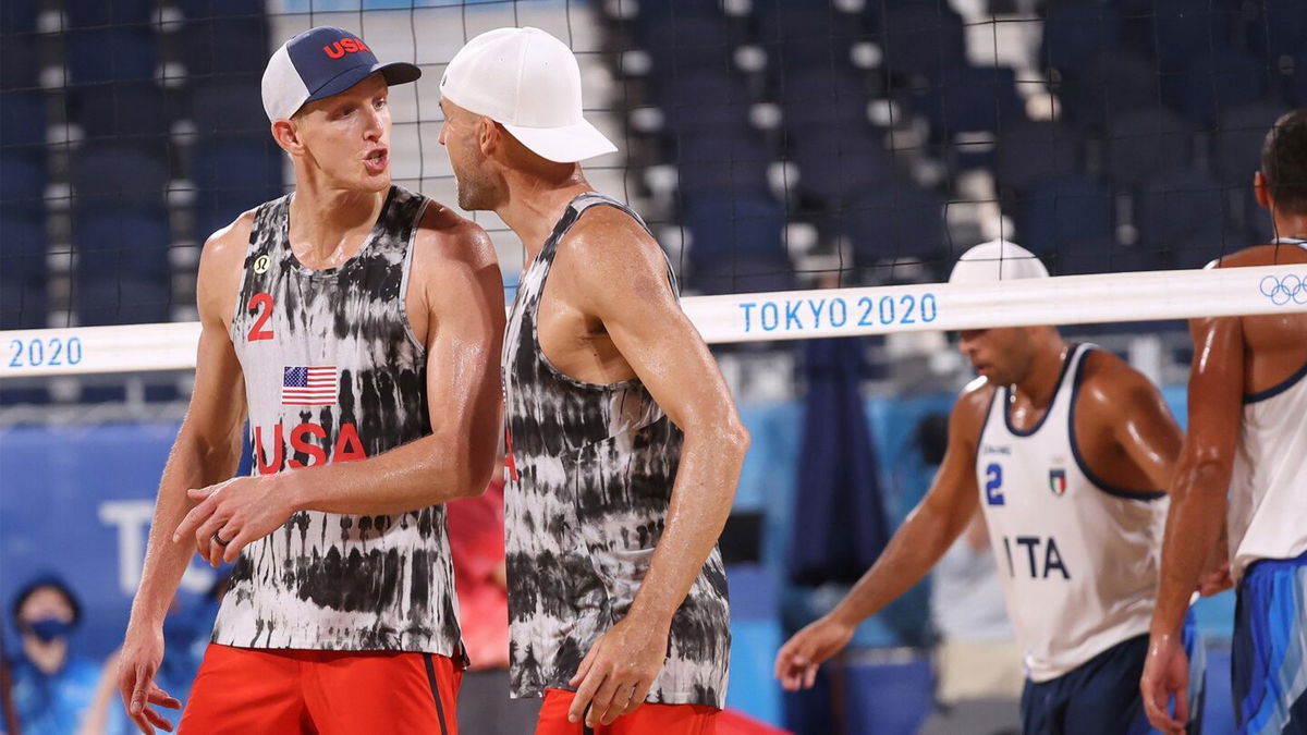 Jacob Gibb and Tri Bourne address each other during a beach volleyball match