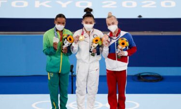 Suni Lee watches back all-around medal ceremony