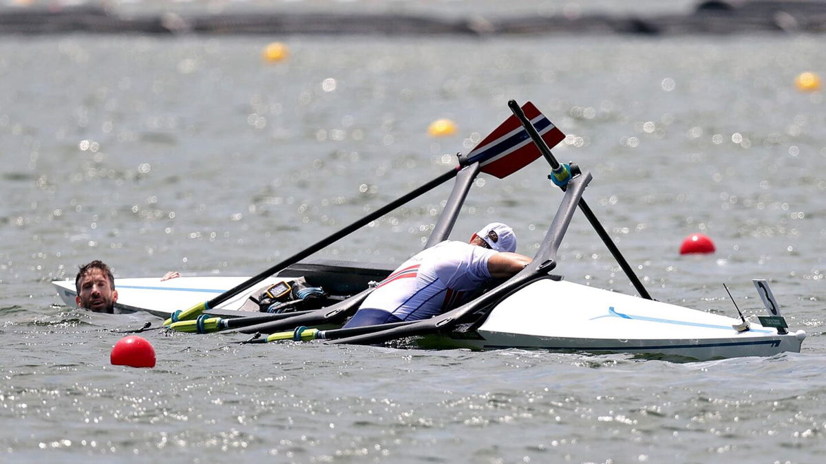 Kristoffer Brun and Are Weierholt Strandli of Team Norway hold on to their capsized boat