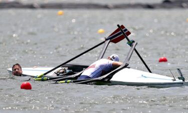 Kristoffer Brun and Are Weierholt Strandli of Team Norway hold on to their capsized boat