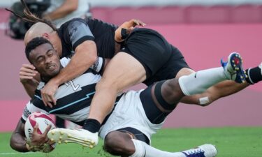 Two rugby players go down after a tackle