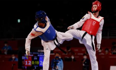 Hakan Recber and Nedzad Husic raise their legs in taekwondo competition