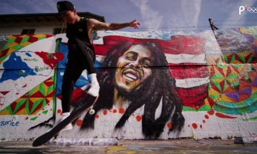 Nyjah Huston skateboards in front of a painted wall