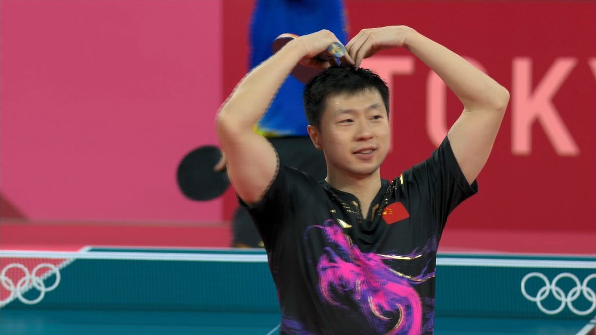 Ma Long gives a hand heart after his gold medal win