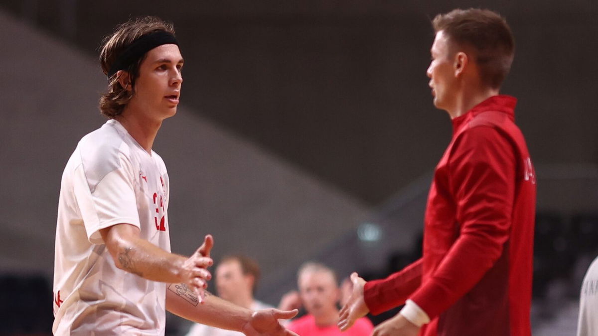 Two opposing players face each other with hands raised