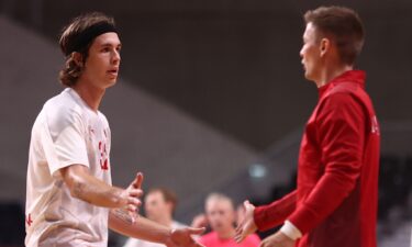 Two opposing players face each other with hands raised