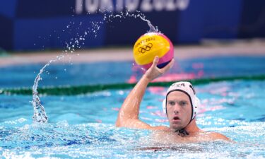 Ben Stevenson carries the ball for Team USA in a water polo game against Japan.