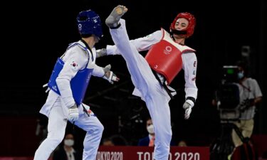 South Korea's Lee Daehoon (Blue) and Uzbekistan's Ulugbek Rashitov (Red) compete in the taekwondo men's -68kg elimination round bout during the Tokyo 2020 Olympic Games at the Makuhari Messe Hall in Tokyo on July 25