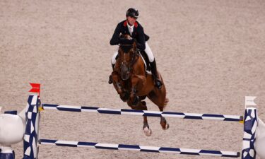 Ben Maher and his horse jump a blue and white jump