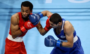 Duke Ragan (red) of Team United States exchanges punches with Albert Batyrgaziev of Team Russian Olympic Committee.