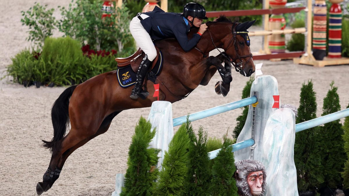 Peder Fredricson and his horse jump over a blue and white jump decorated like ice