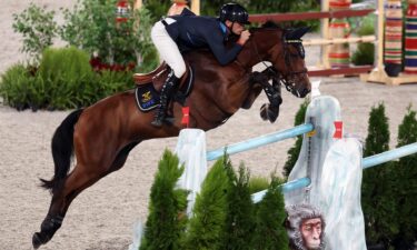 Peder Fredricson and his horse jump over a blue and white jump decorated like ice