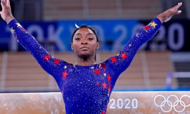 Simone Biles salutes after beam