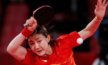 Red-clad Chen Meng of China watches her shot in a semifinal versus Germany