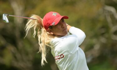 Maha Haddioui of Morocco's iron is caught under her blonde hair after a shot in first round action