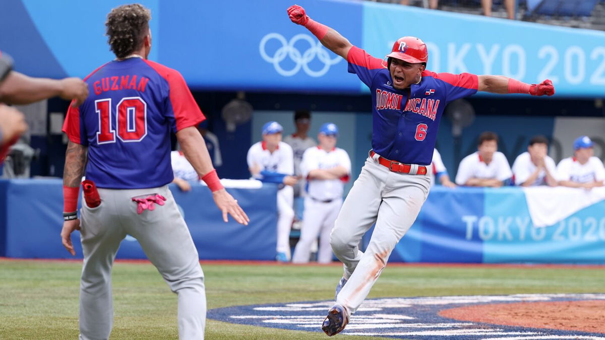 Infielder Erick Mejia of the Dominican Republic celebrates scoring a run with his team mate Jeison Guzman after a two-run double by Juan Francisco during the bronze medal game between Dominican Republic and South Korea.