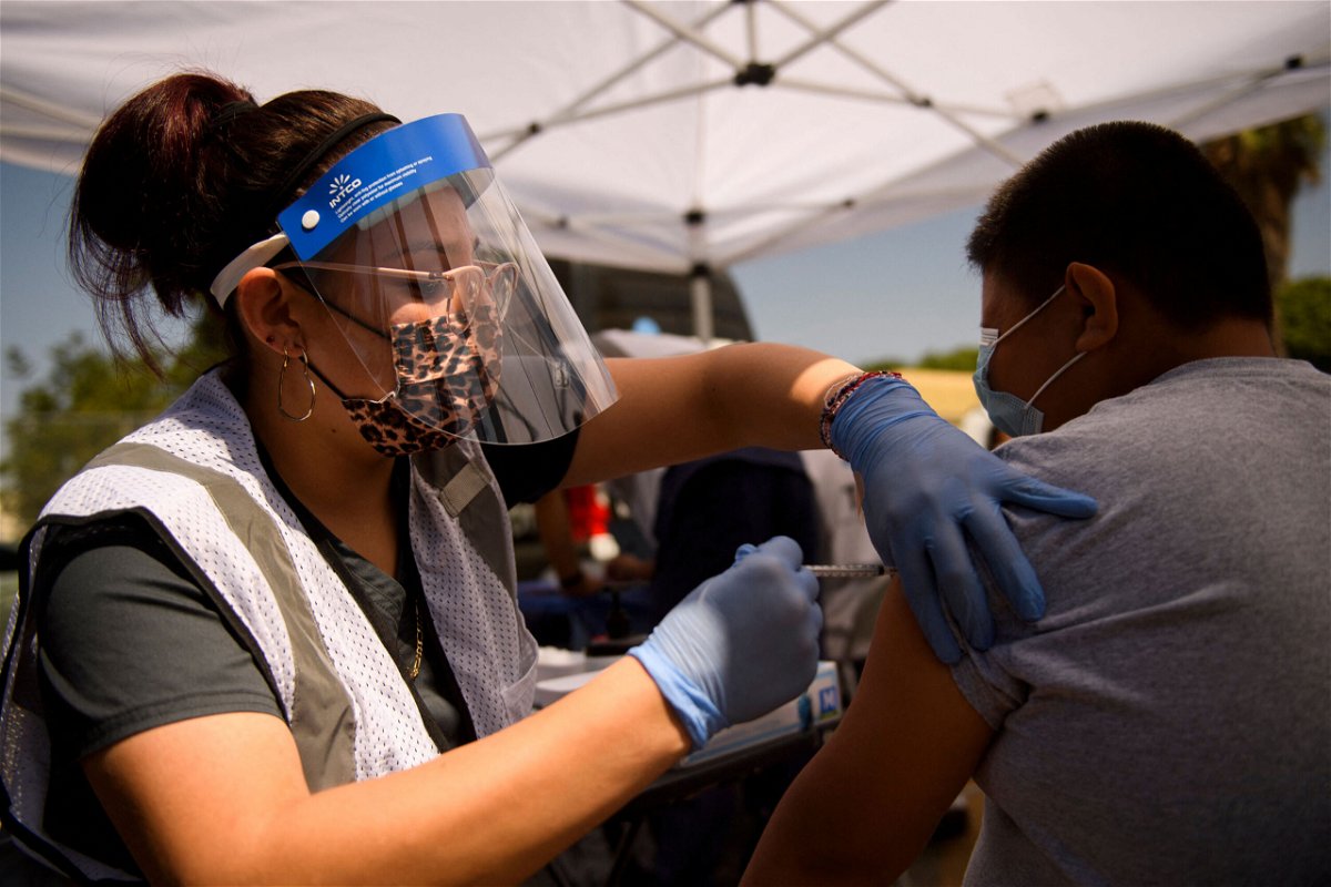<i>Patrick T. Fallon/AFP/Getty Images</i><br/>A 12-year-old receives a first dose of the Pfizer Covid-19 vaccine at a mobile vaccination clinic during a back to school event in Los Angeles.