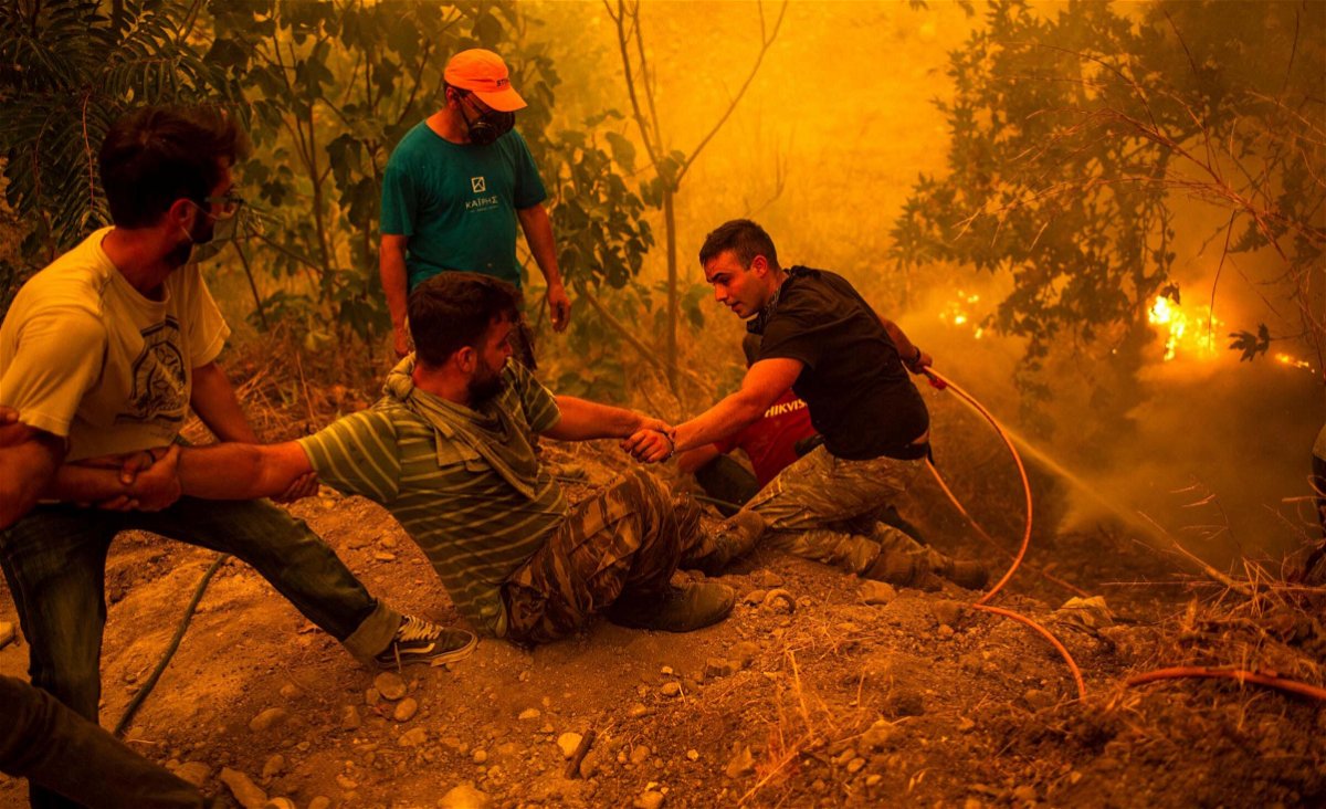 <i>Angelos Tzortzinis/AFP/Getty Images</i><br/>Local residents fight the wildfire in the village of Gouves on the Evia in Greece.