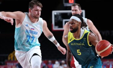 Patty Mills dribbles the ball past Slovenia's Luka Doncic.