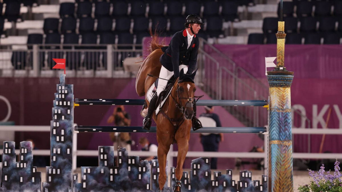 Ben Maher and his horse are part way to landing off a grey and black jump