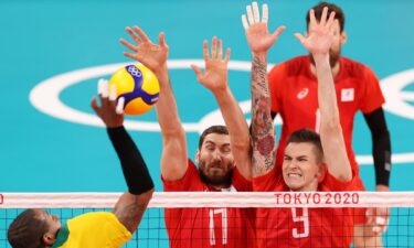 Maxim Mikhaylov #17 of Team ROC and Ivan Iakovlev #9 defend against the strike by Yoandy Leal Hidalgo #9 of Team Brazil during the Men's Semifinals volleyball on day thirteen of the Tokyo 2020 Olympic Games