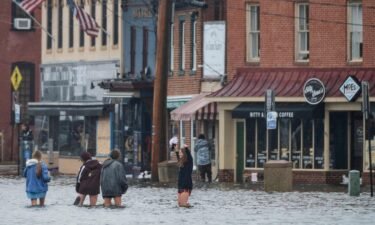 A group of people wade through flood waters in downtown Annapolis