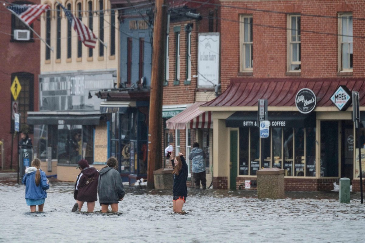 <i>JIM WATSON/AFP/Getty Images</i><br/>A group of people wade through flood waters in downtown Annapolis