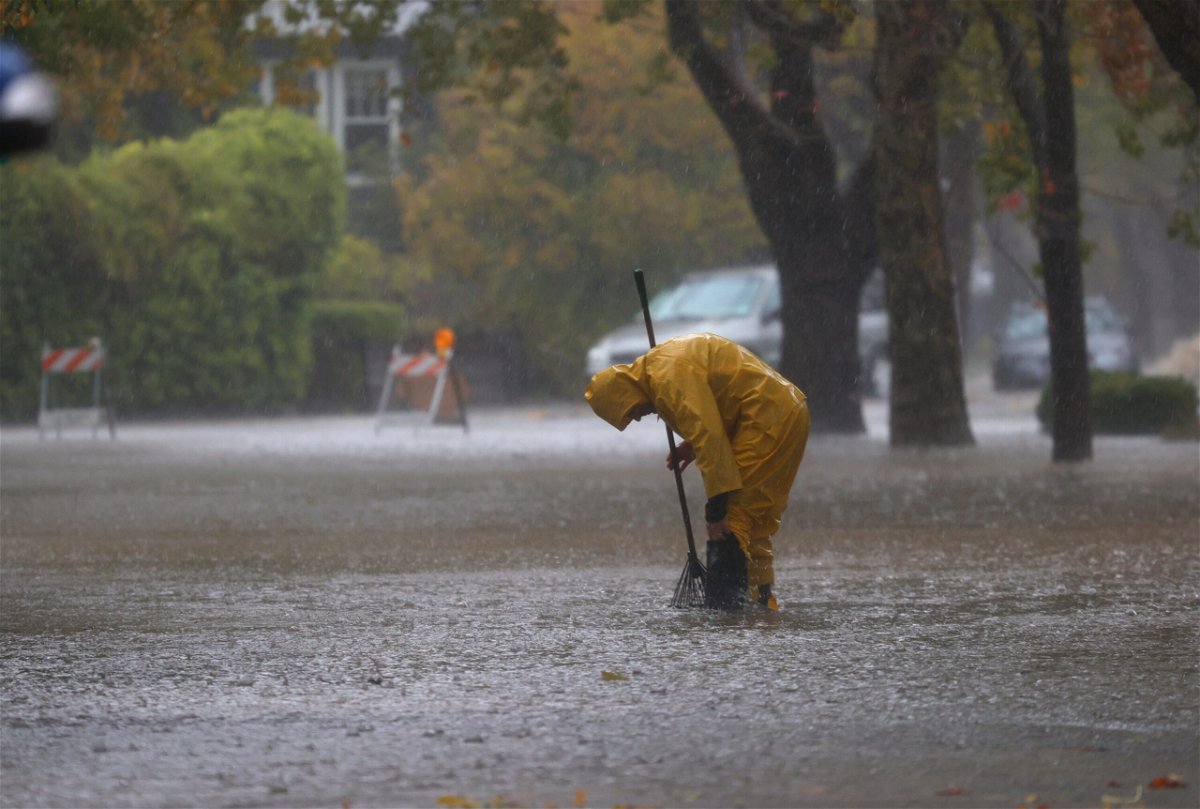 <i>Justin Sullivan/Getty Images</i><br/>A worker tries to clear a drain in a flooded street Sunday in San Rafael