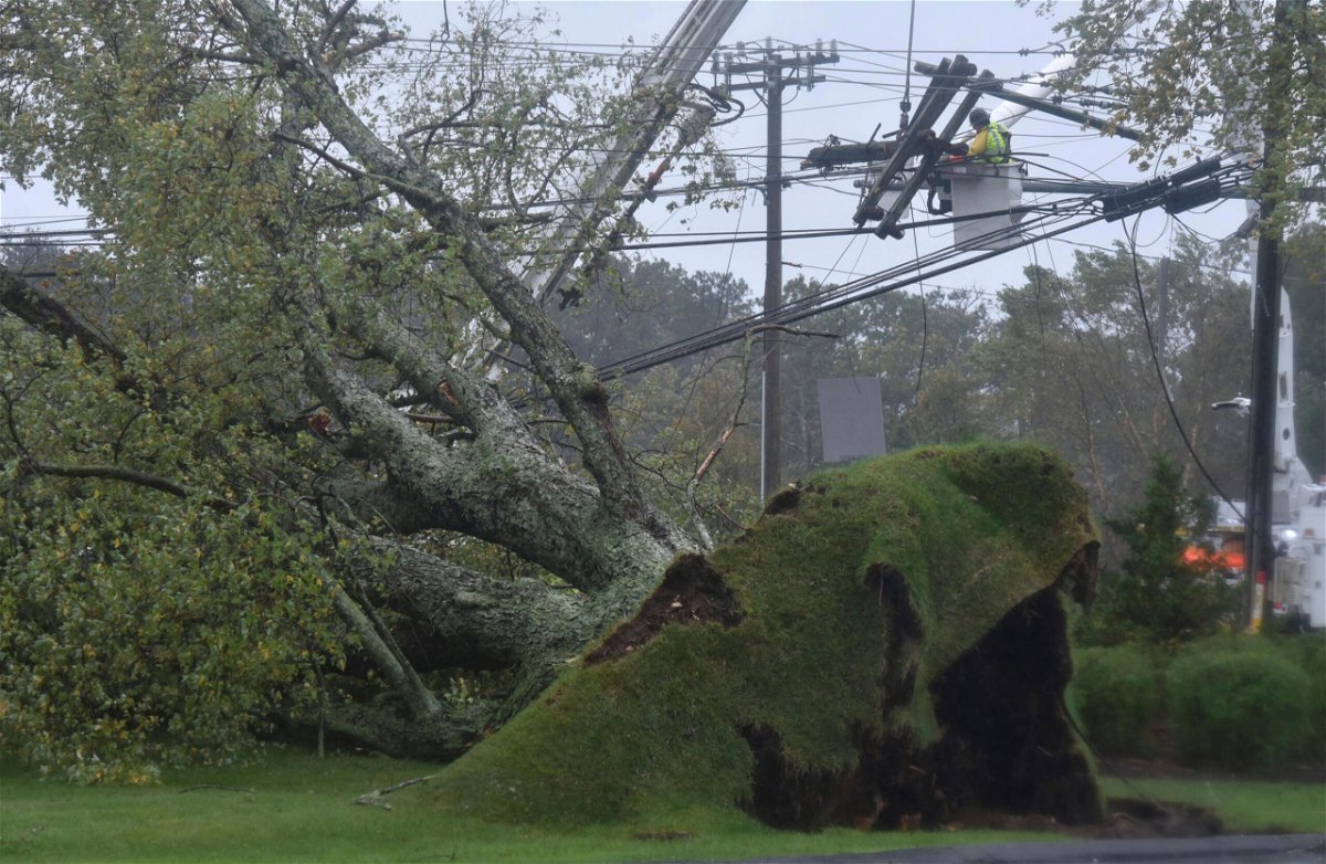 <i>Steve Heaslip/Cape Cod Times/AP</i><br/>Crews are working to restore power to hundreds of thousands in New England. An uprooted large tree brought down power lines in Sandwich