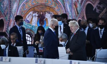 US President Joe Biden (C) and British Prime Minister Boris Johnson talk prior to the opening session of the G20 of World Leaders Summit on October 30