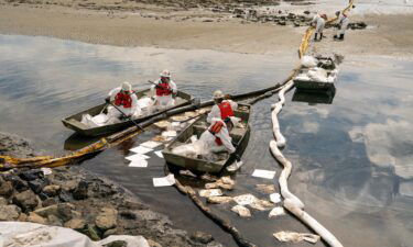 Patriot Environmental employees work Monday to clear oil from the surface of the water inside Talbert Marsh