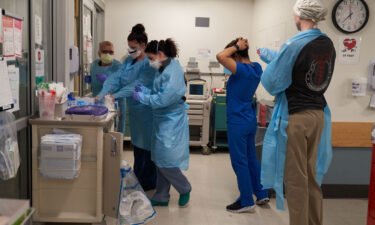 Healthcare workers put on PPE on the Covid-19 ICU floor of the University of Massachusetts (UMass) Memorial Hospital in Worcester