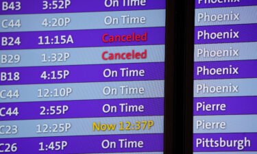 Canceled flights are noted in red on an electronic arrival board in the terminal of Denver International Airport
