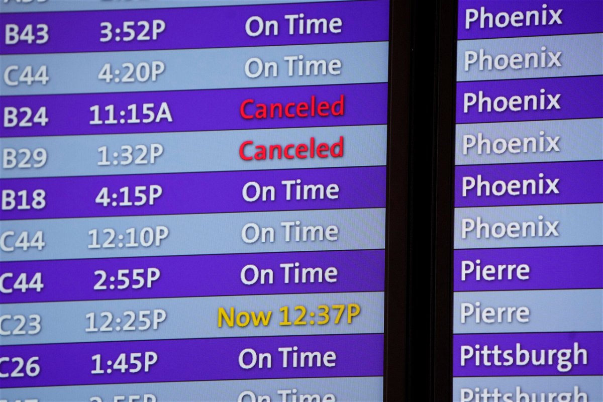 <i>David Zalubowski/AP</i><br/>Canceled flights are noted in red on an electronic arrival board in the terminal of Denver International Airport
