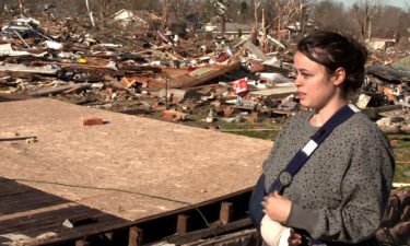 Tornado survivor Breeana Glisson beside what had been her home in Dawson Springs.