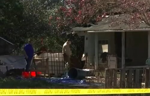 Mobile County Sheriff's Office investigators are seen at a Lott Road home were a body was found buried beneath the floorboards.